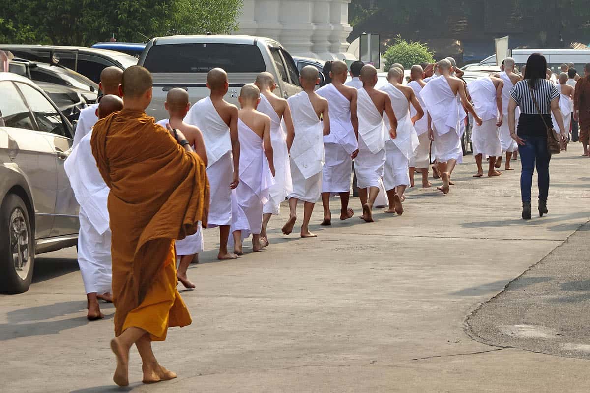 A line of teenage boys dressed in white robes