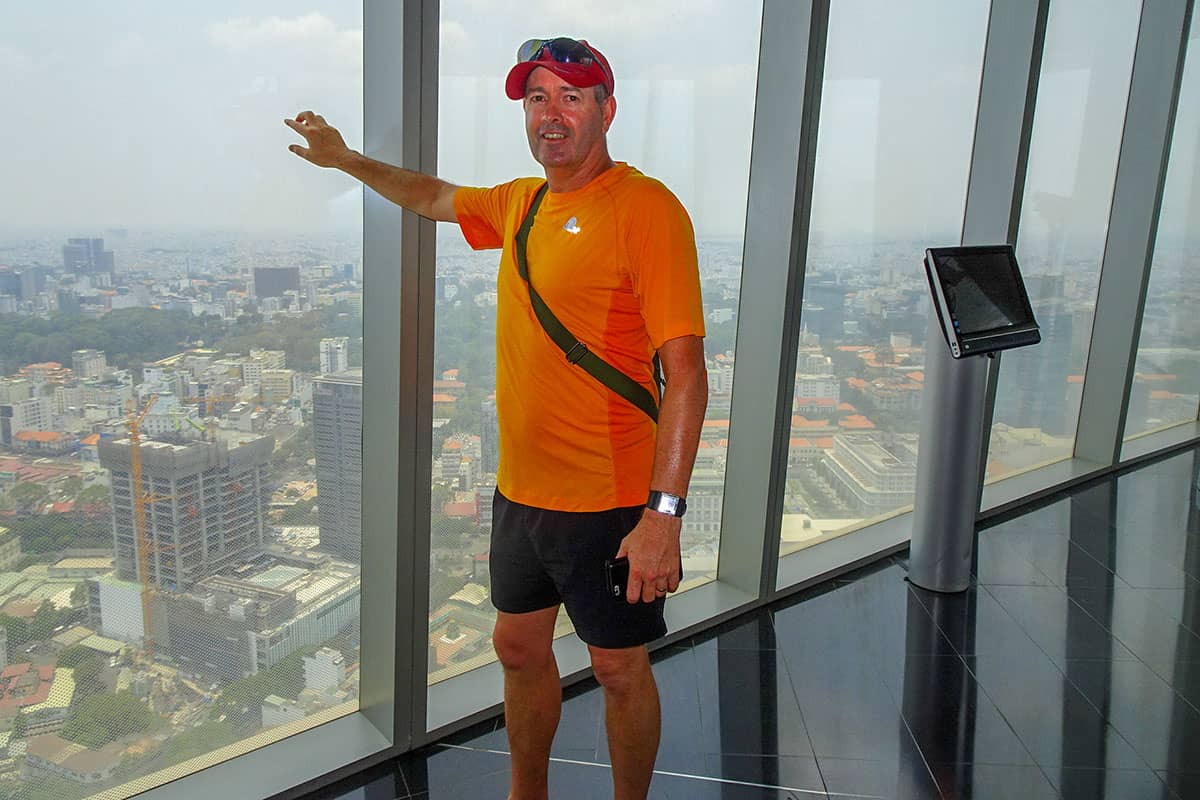 A man touching a glass window on the 50th floor of a building