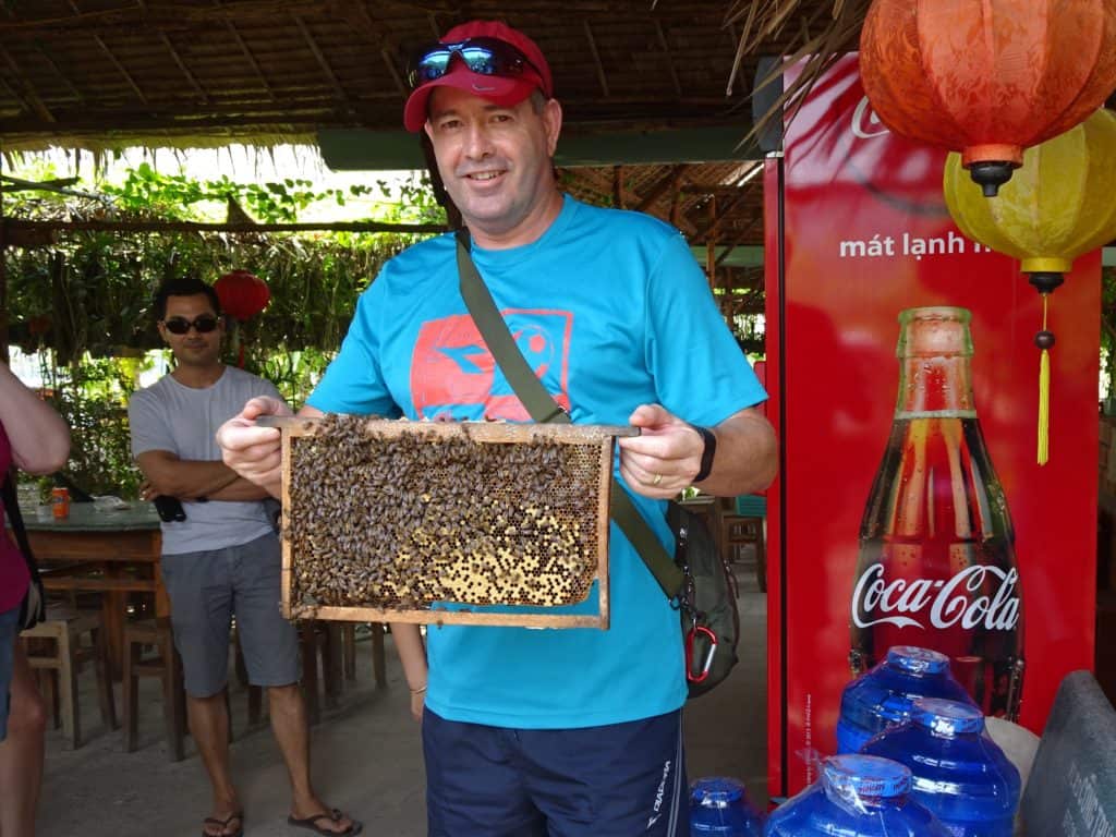 Man holding a honey bee tray