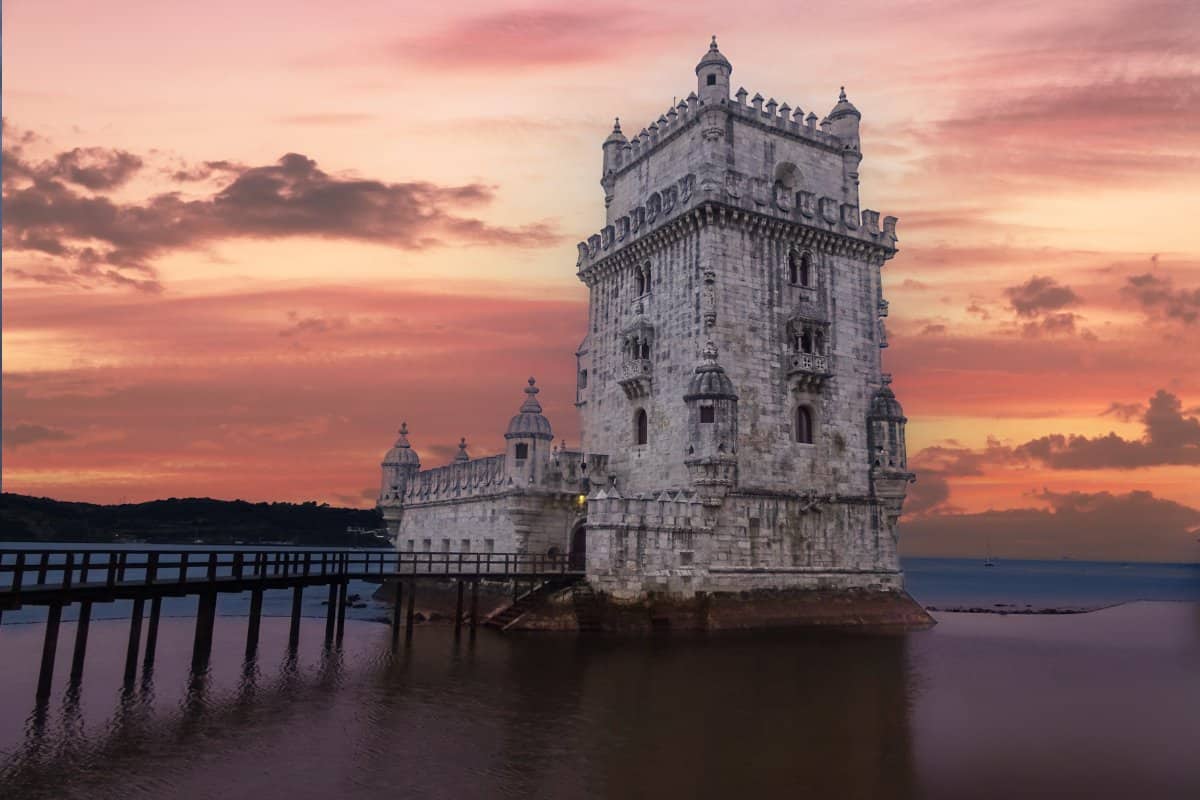 A stone castle in water at sunset