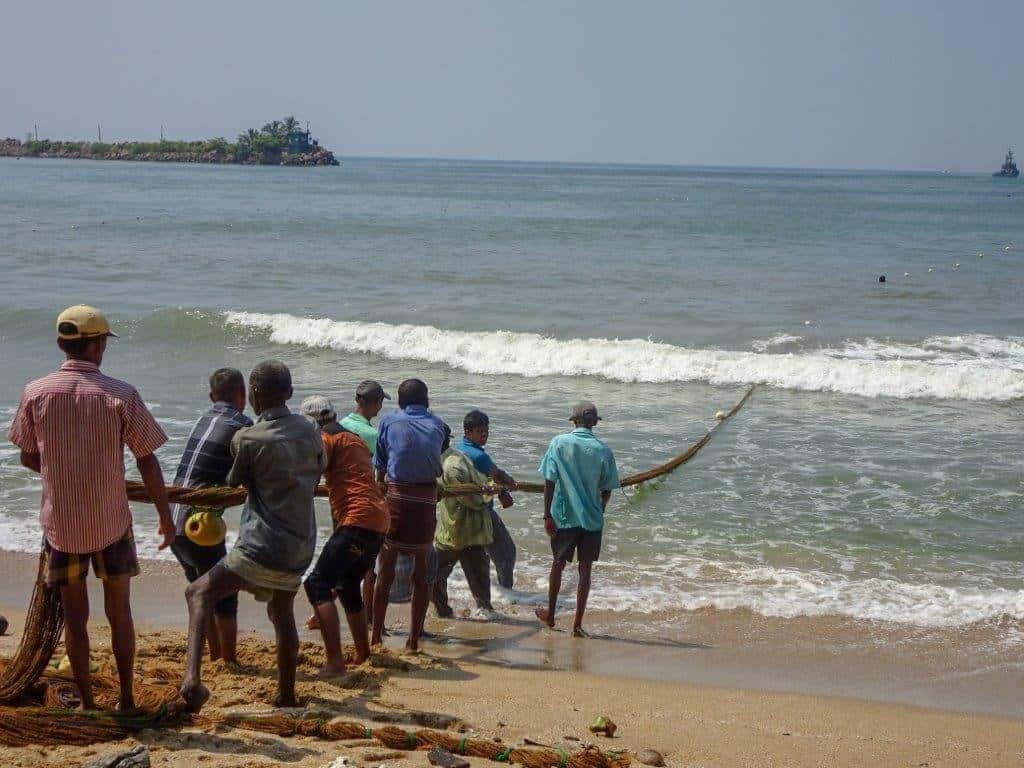 men pulling on fishing rope