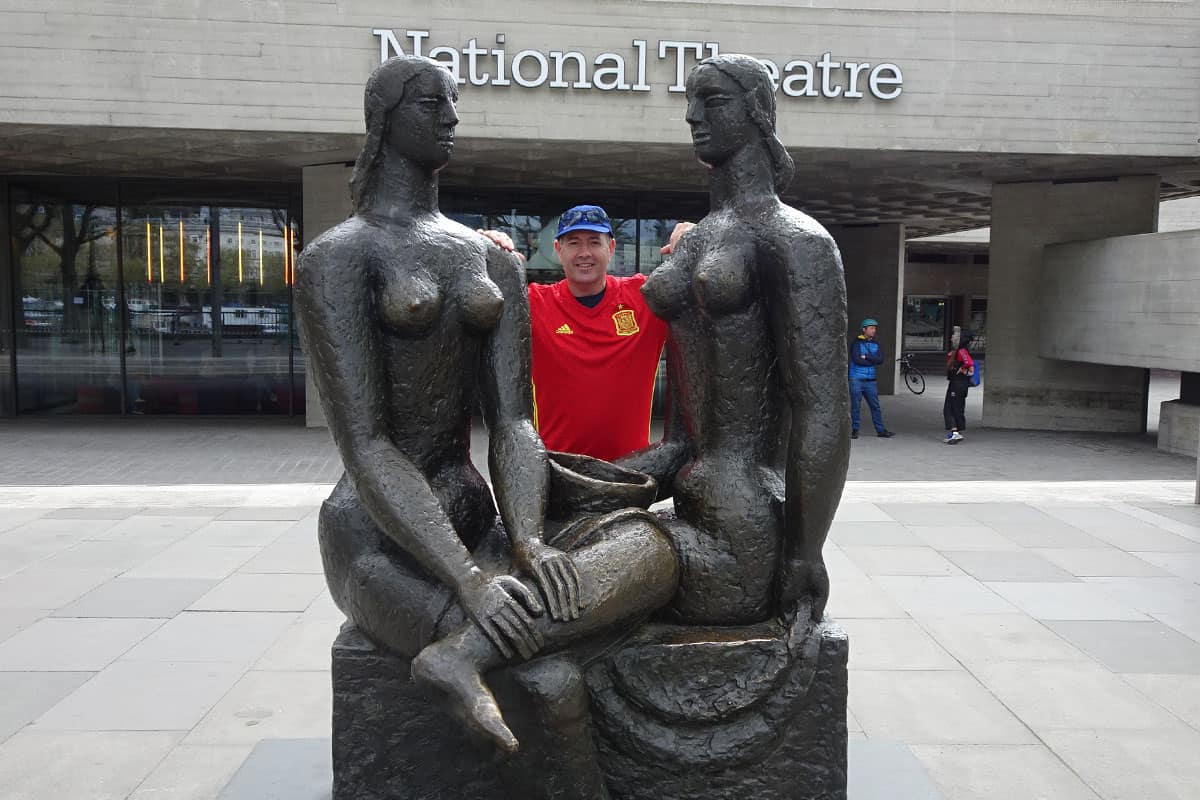 A man between two female statues