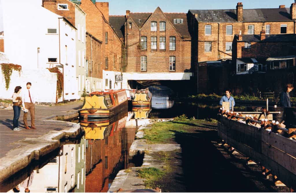 Man and woman standing alongside a narrow canal