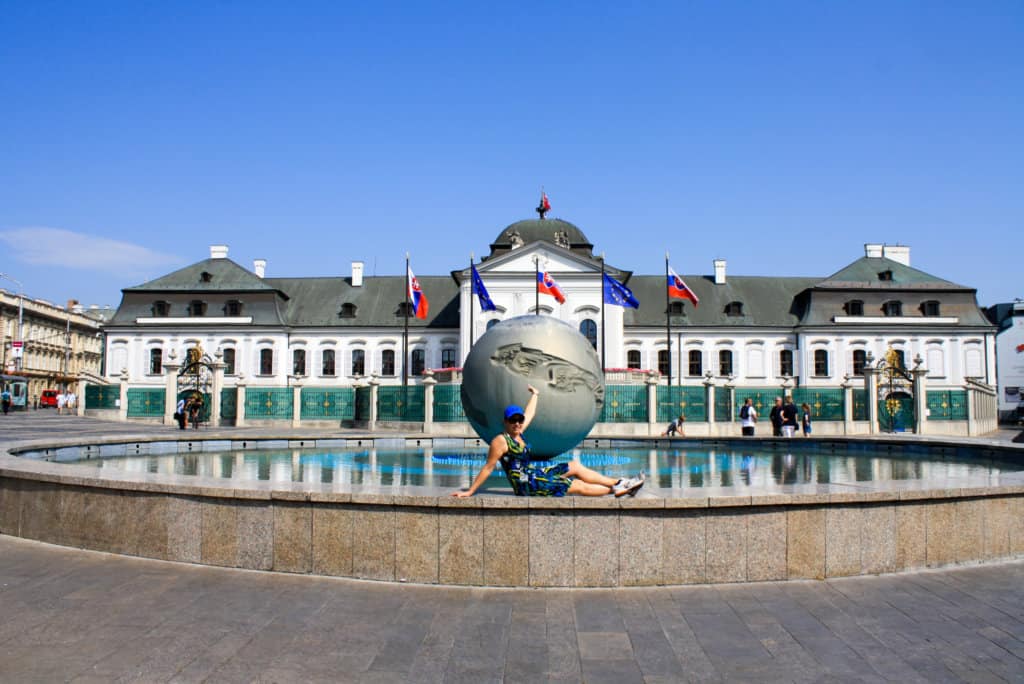 fountain with a large ball in front of building