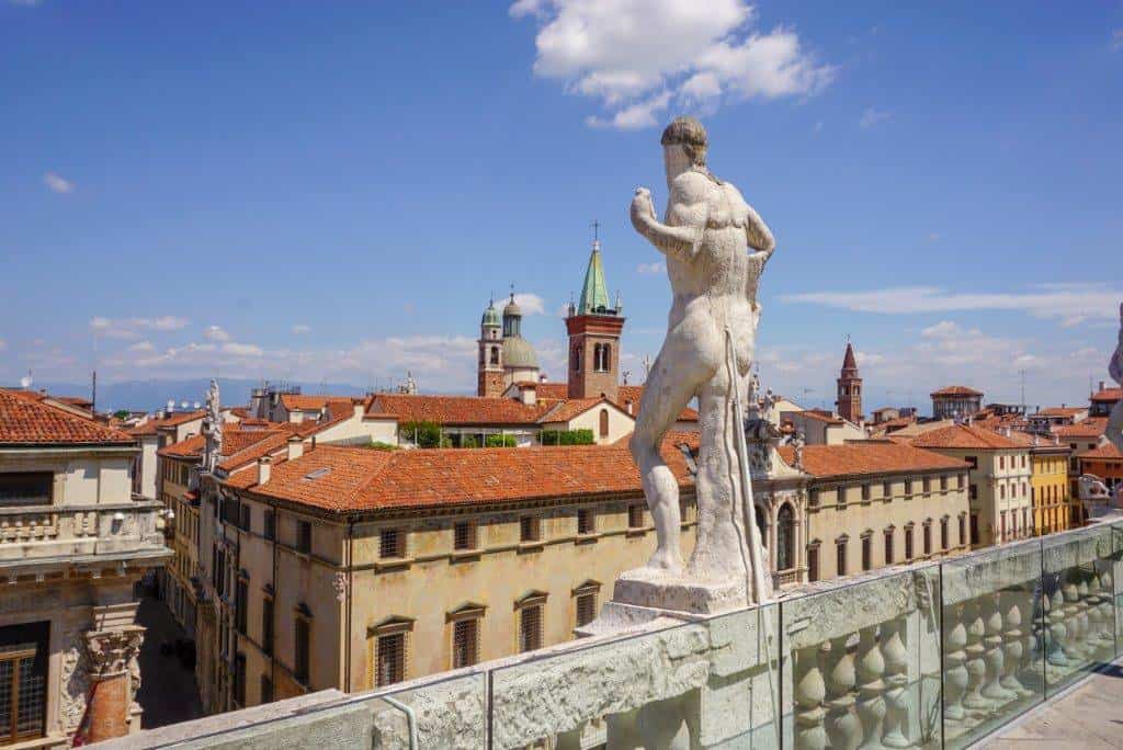 Statue of a man on top of a building looking down