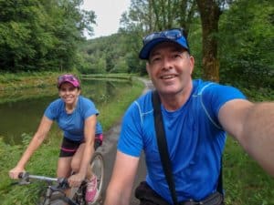 Man and woman on bikes next to a canal
