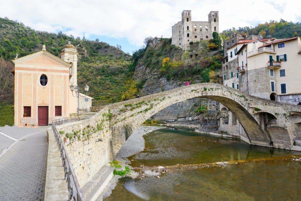 Arch bridge over a river with a castle on the hill