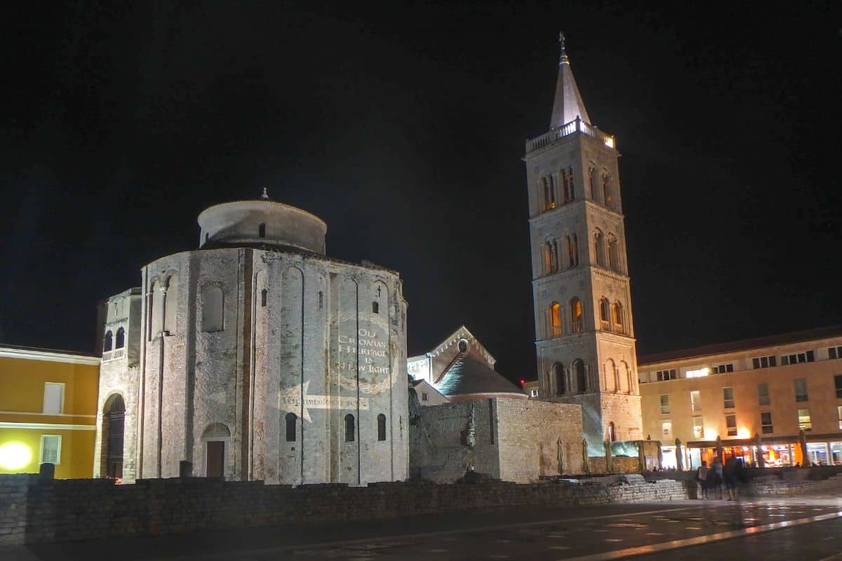 A church and tower lit up at night