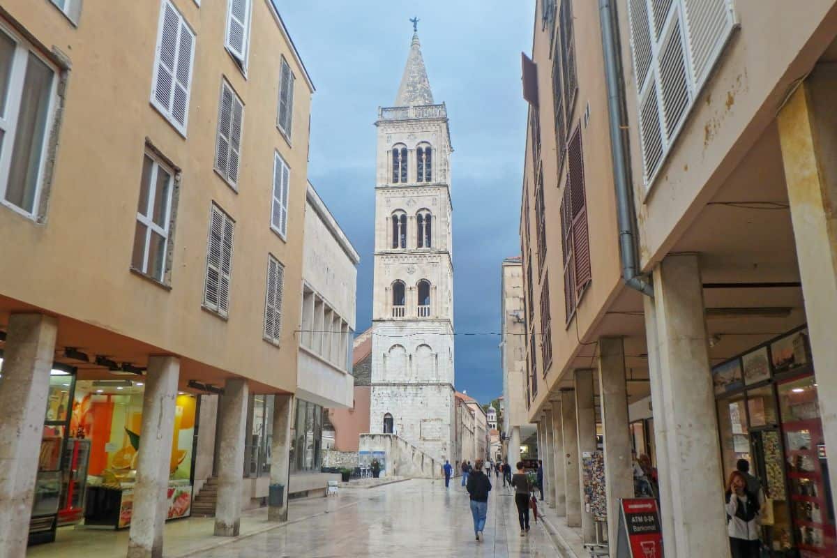 A paved street with a tower in the distance in Zadar, Croatia