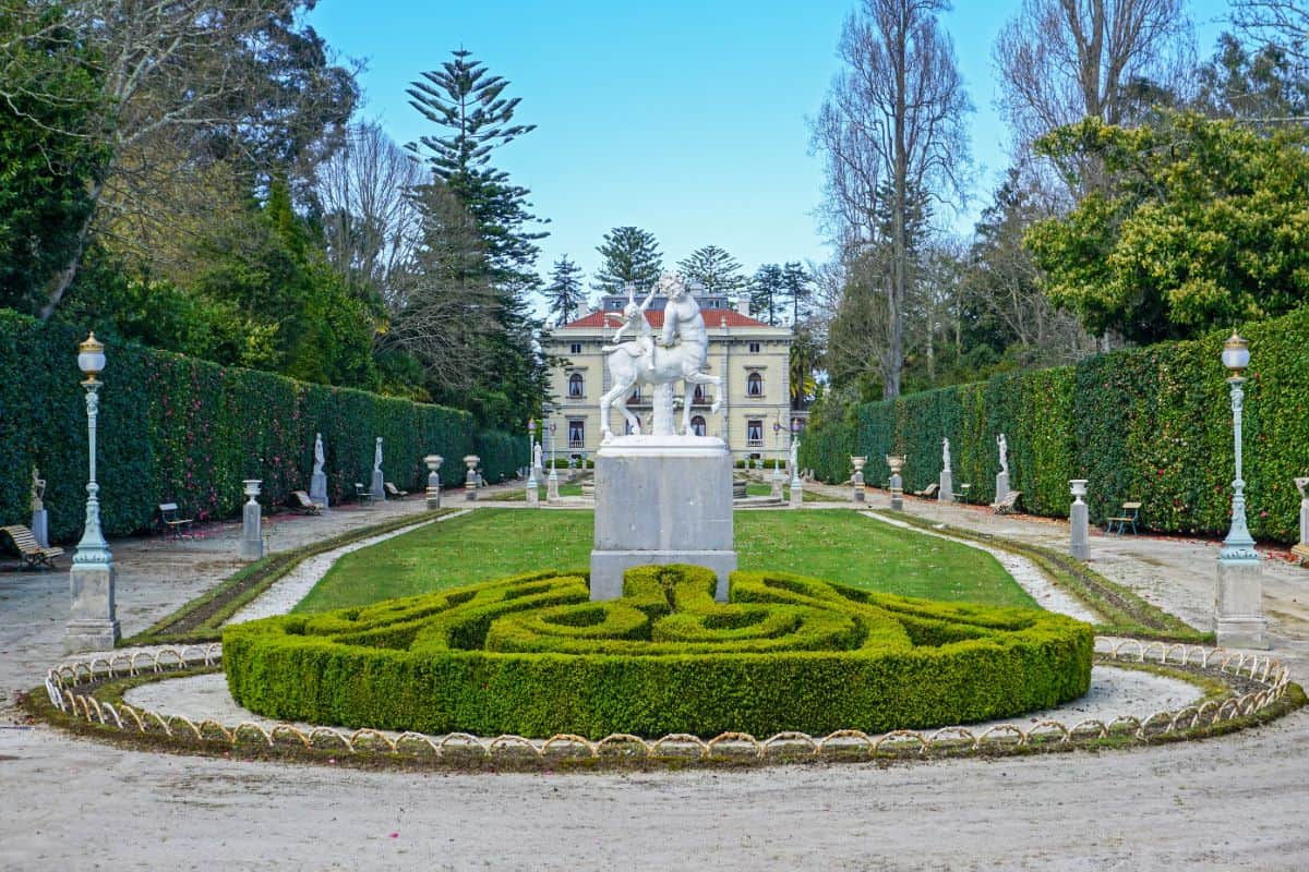 A palace with a green garden and statue in from