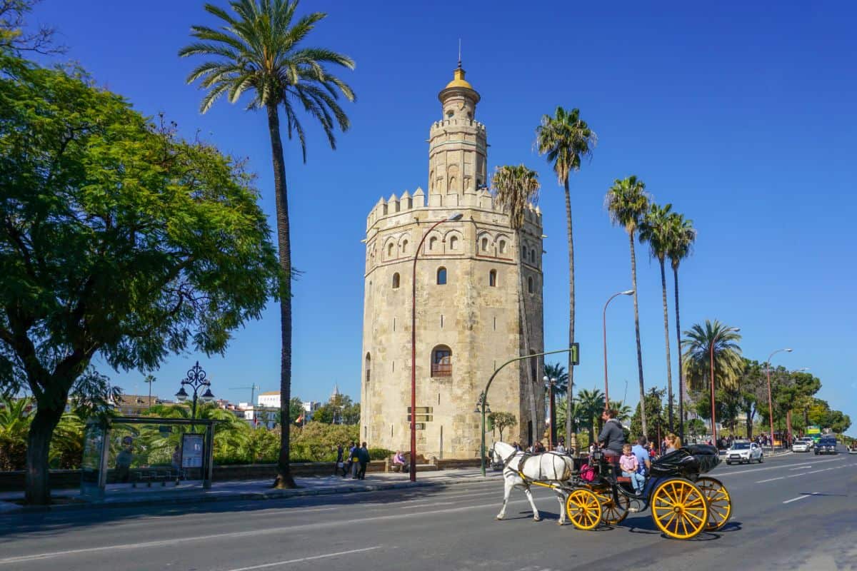 A horse and cart in front of a tower