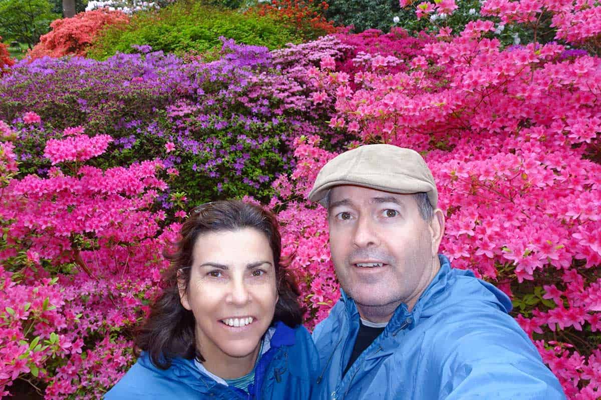 Man and woman in front of pink flower bush