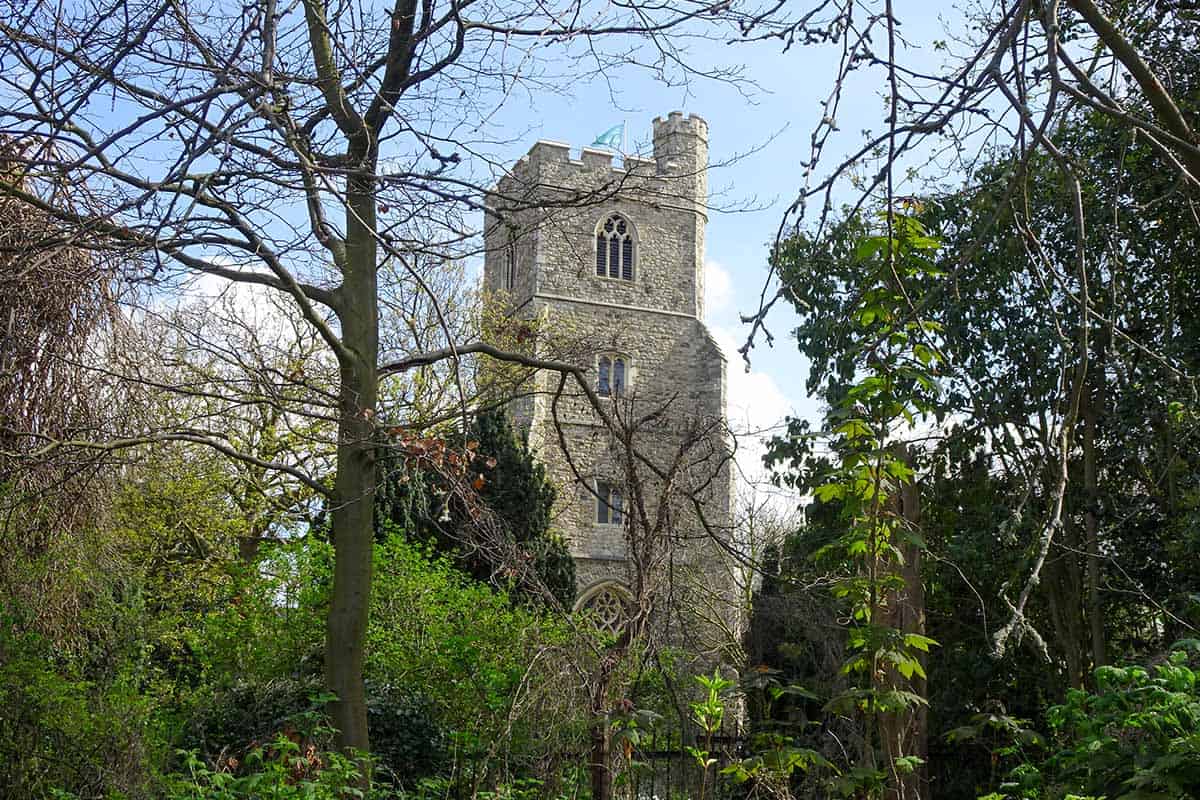 Stone square church tower amongst trees
