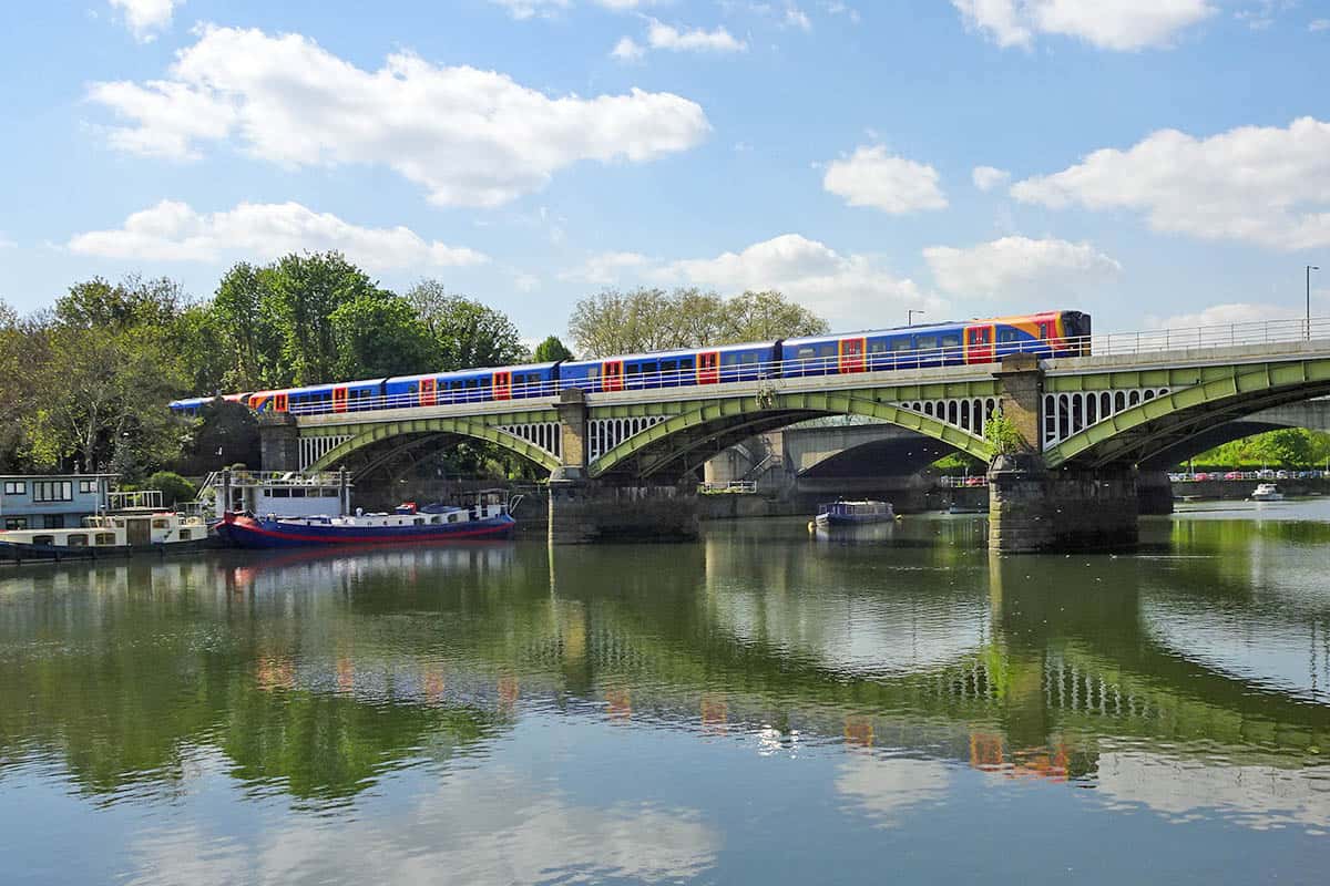 Red and Blue passenger train crossing over a bridge