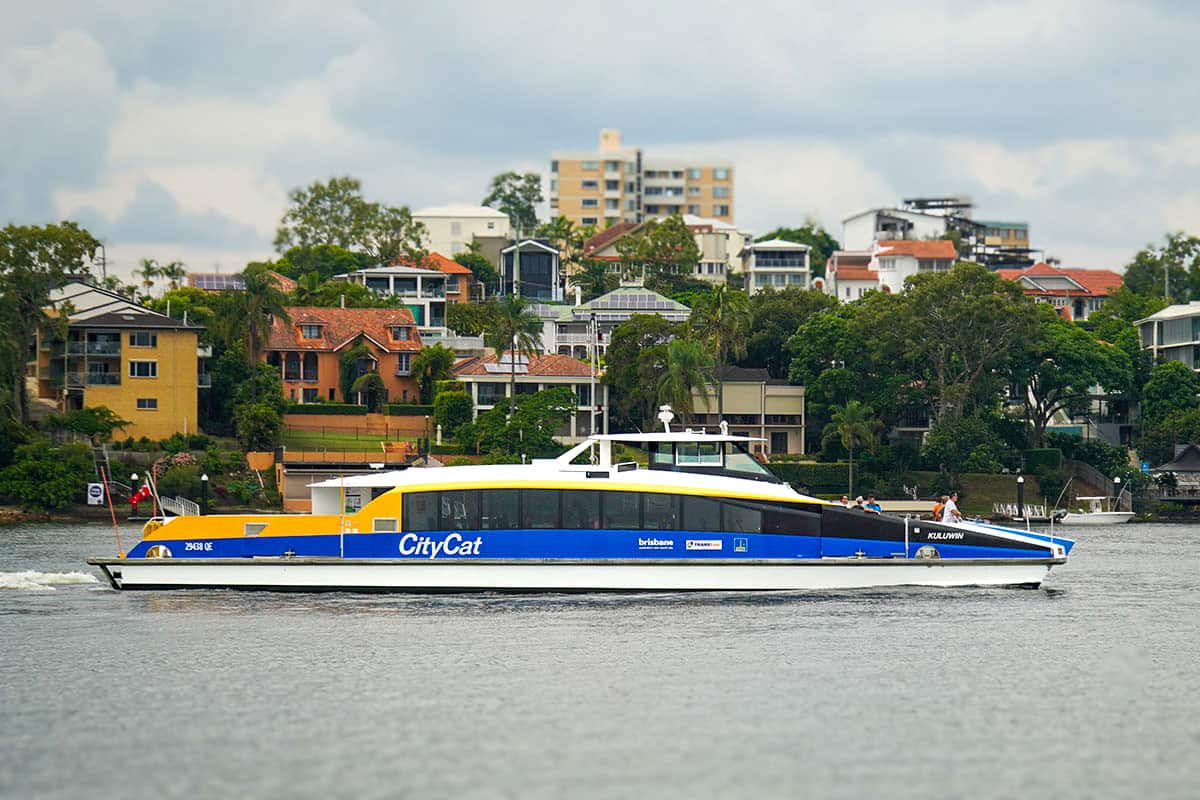 Fast ferry on the river passing by houses