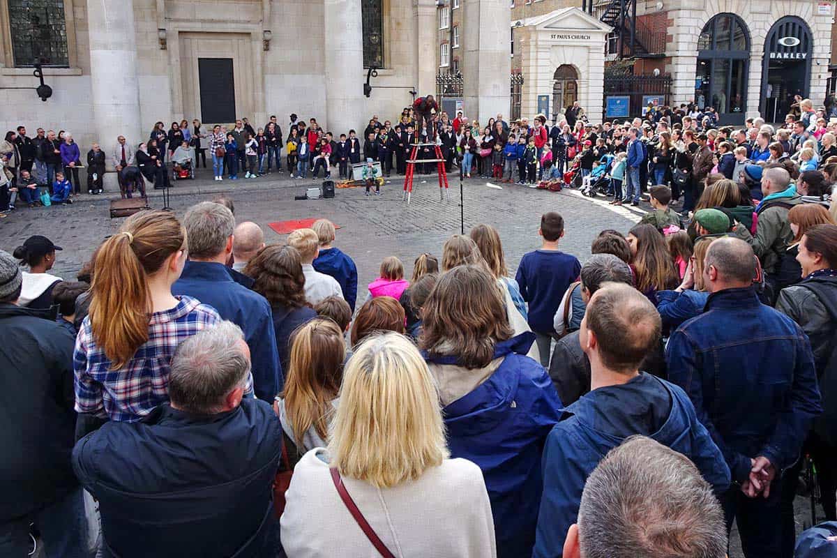 A crowd gathered around a performer in a square