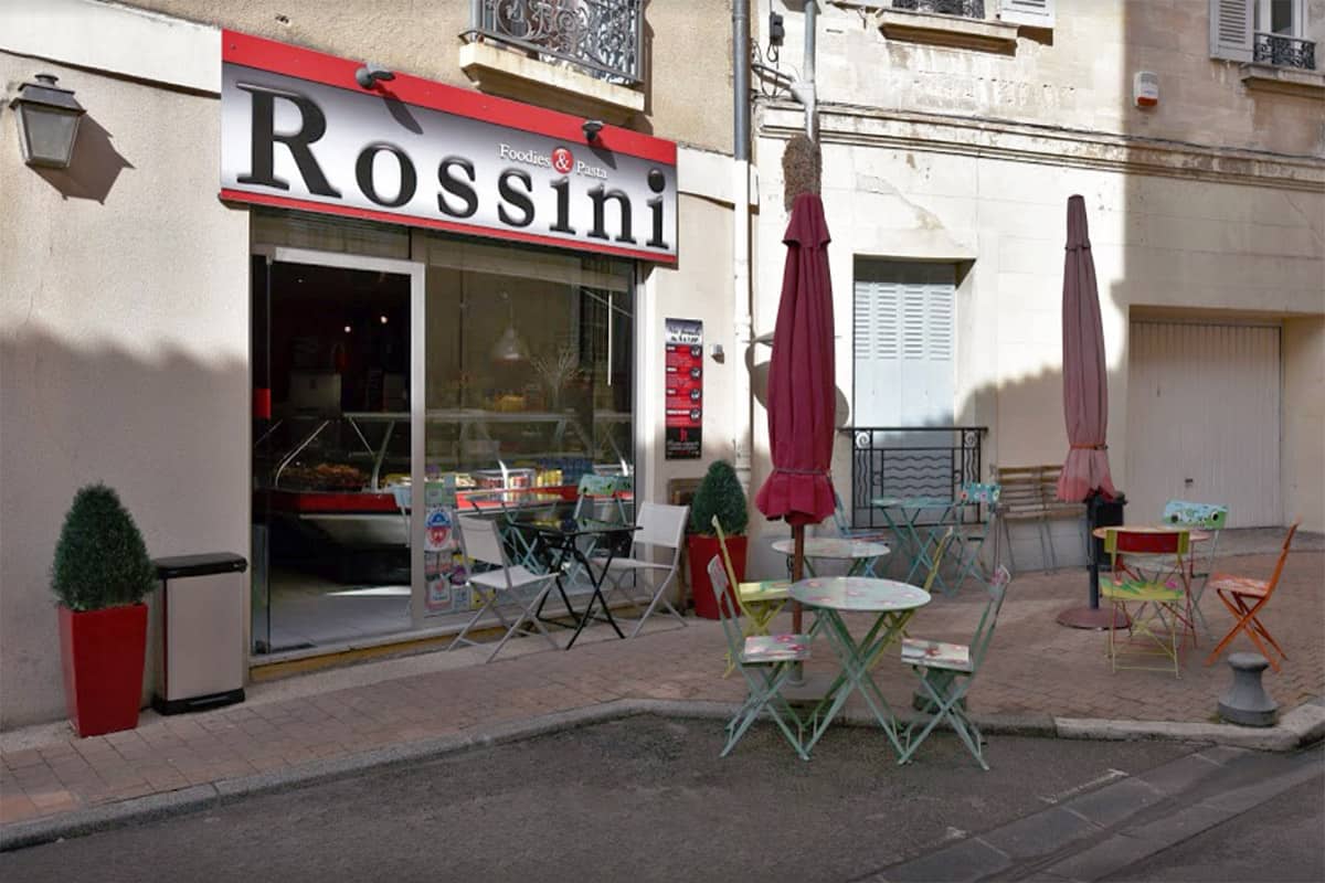 Tables and chairs set up outside a small cafe