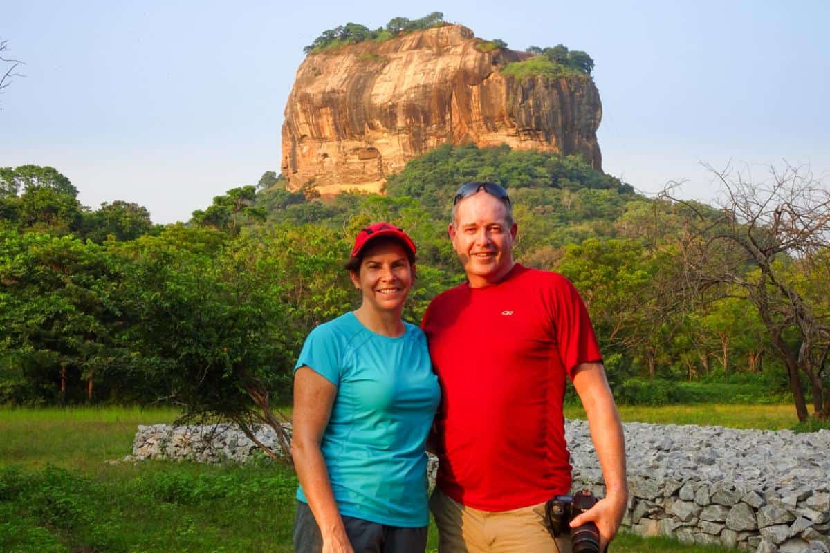 A couple posing with a huge rock formation in the background